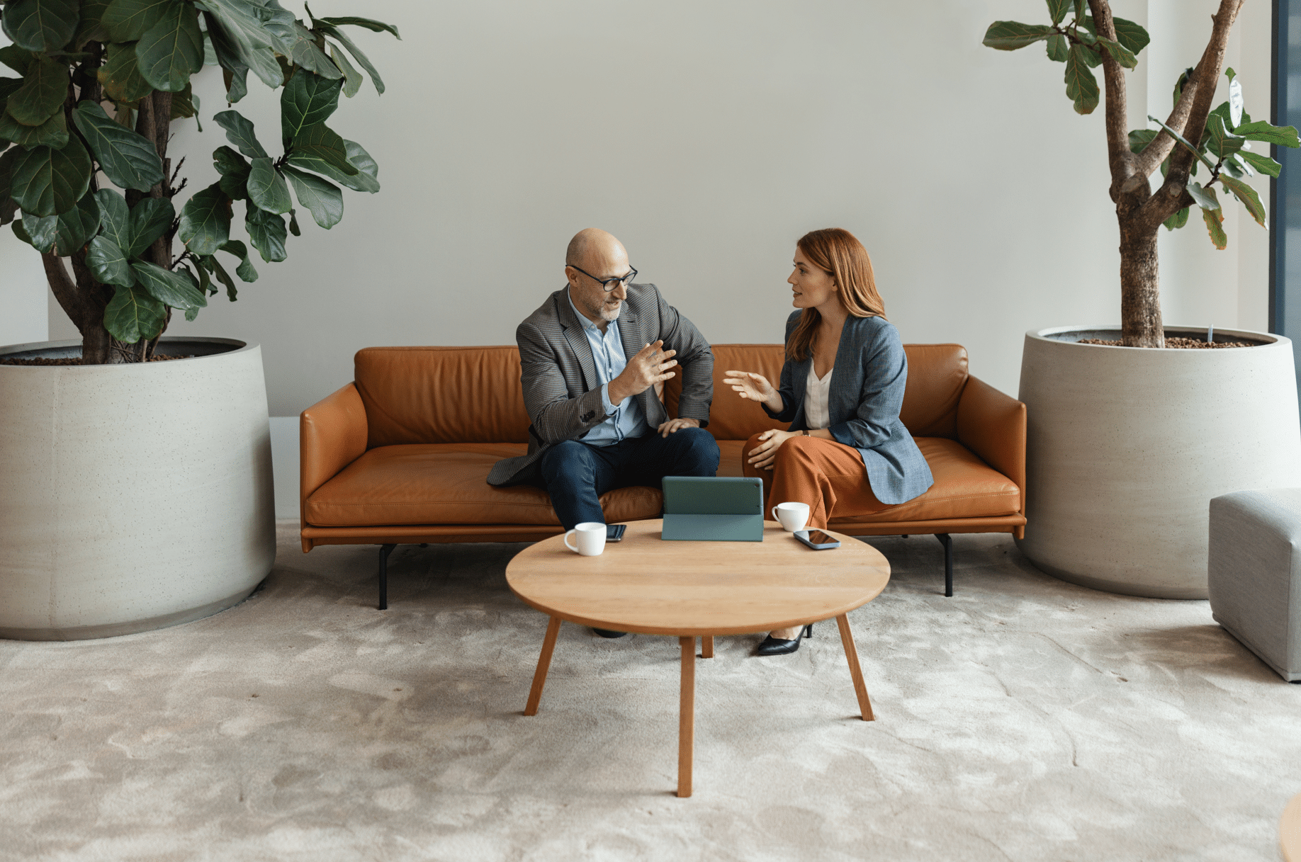 A casual yet focused conversation unfolds between two professionals, as they review information on a tablet, embodying a modern approach to teamwork and collaboration.