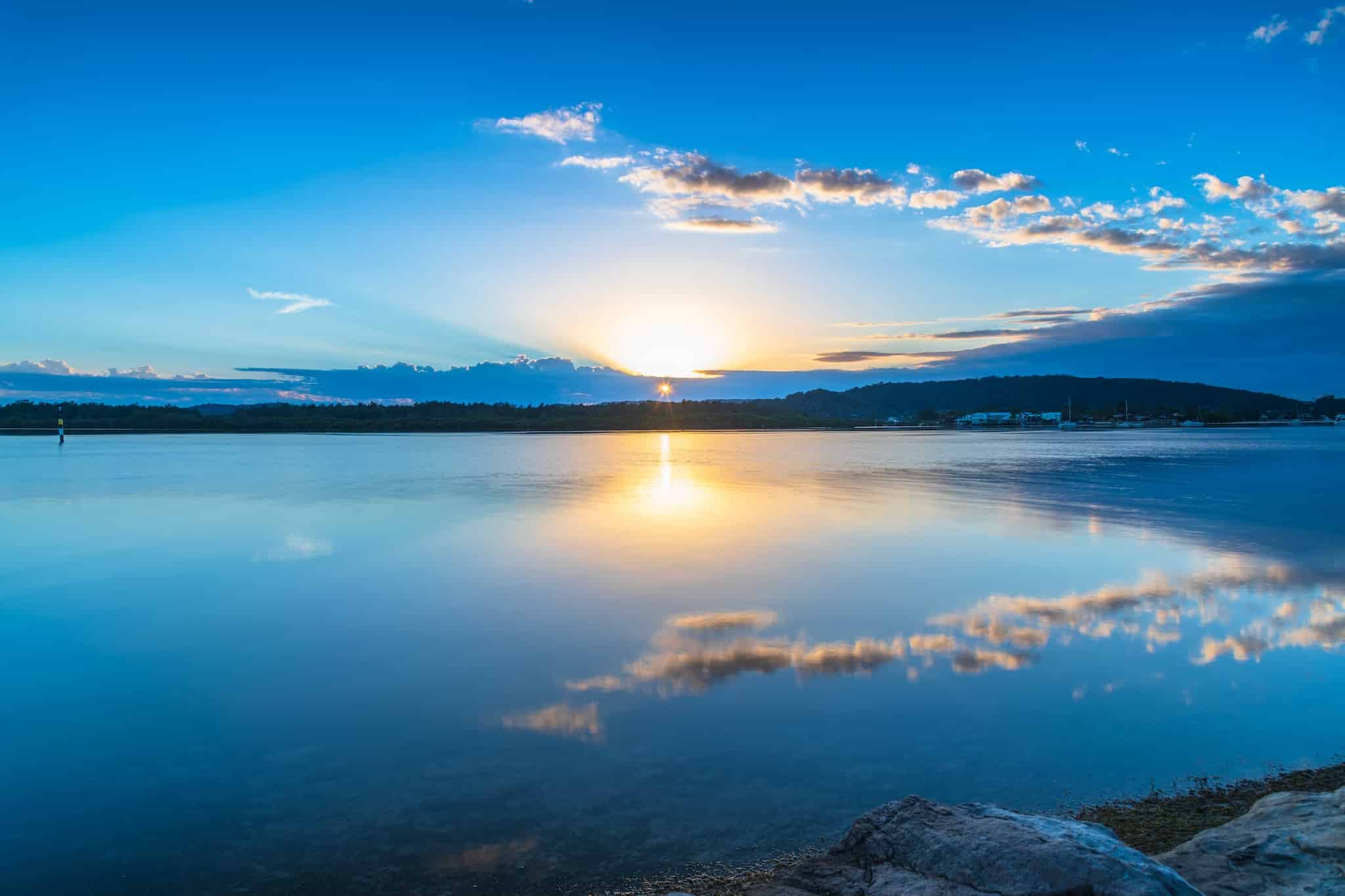 Sun rising over lake background