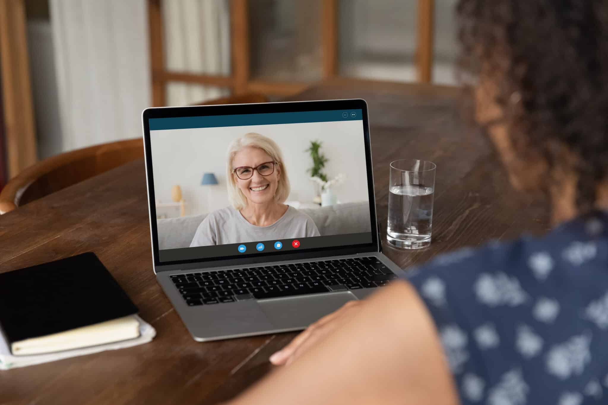 Middle age woman on screen of laptop sharing feedback during a client feedback session