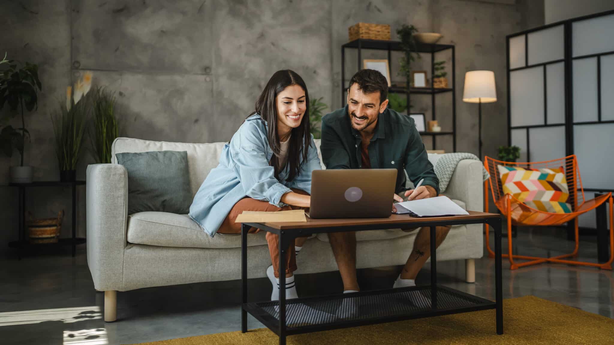 Thirtysomething Latino couple at home on computer having client feedback conversation