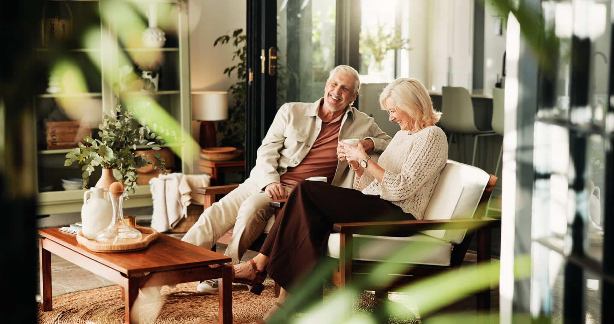An older couple laughing while sharing a personal story during an online client feedback conversation